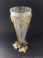 Full view of the tall crackled glass vase with brass grape and vine overlay.
