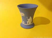 Wedgwood fluted vase with classical white relief figures on sky blue Jasperware background, showing full vase profile.