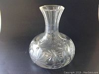 Full view of the vase showing its shape and etched floral pattern on the bulbous body and narrow neck.