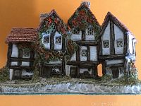 Front and side views of the miniature model showing detailed timber framing, ivy-covered roofs, and windows.