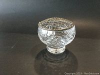 Side view of the cut crystal flower frog with metal grid top showing diamond-cut pattern and round base