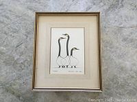 Framed print artwork depicting three stylized birds by Benjamin Chee Chee, displayed on concrete floor.