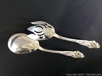 Both silver plate serving spoons shown side by side on a black background, displaying handles and spoon bowls