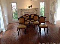 Six chairs arranged before fireplace