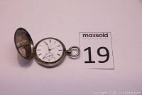 Open view showing white enamel dial, Roman numerals, subsidiary seconds and gold-tone hands.