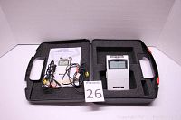 Open carrying case showing TENS unit in foam padding along with leads and manual inside case