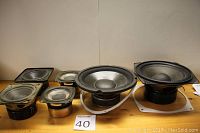 Front view of six speaker drivers showing various sized cones and frames, including woofers and midranges.