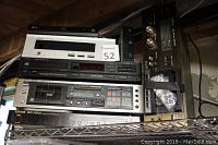 Photo of a stack of vintage electronics on a metal shelf including LG, Technics, BMG branded devices, untested, showing front controls and buttons