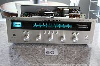 Front view showing champagne aluminum faceplate, illuminated blue tuning scale, control knobs and tuning meter.
