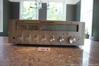 Front view showing brushed aluminum front panel, tuner scale, VU meters and control knobs