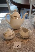 Full view of tea set pieces (teapot, creamer, sugar bowl) with seller lot number in frame