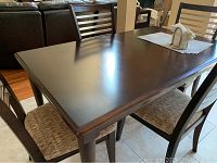 View of rectangular wooden kitchen table surface and two chairs