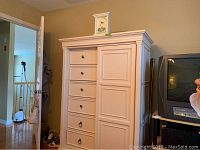 Full view of tall white dresser armoire showing six drawers left and sliding door right