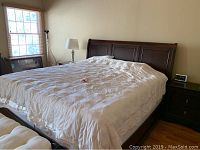 Full view of the king size bed with headboard and comforter on top, showing panel design on headboard.
