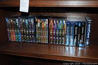 Front view of DVD box sets including FarScape, Battlestar Galactica, and Outer Limits on a shelf.