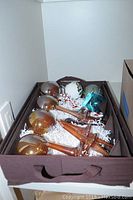 Box with glass Christmas ornaments including gold spheres and elongated teardrop shapes