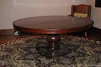 Full view of round hardwood table on patterned rug