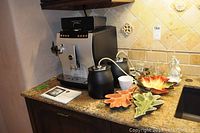 Front view of Jura Impressa Z5 machine with control panel and milk cooler attachments on granite countertop