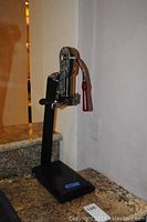 Full view of the Legacy wine bottle opener mounted on the marble base on a granite countertop.