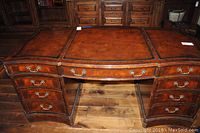 Front view of solid wood desk showing curved front, leather top and drawer layout