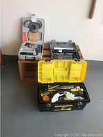 Full view of all items: Black & Decker drill kit in case on the left, American cordless screwdriver kit on the right, and yellow-lid black tool box with assorted contents in front.