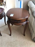 Front and side view of wooden end table with curved legs and drawer closed