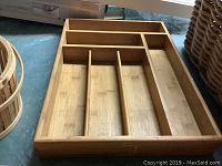 Photo showing wooden cutlery drawer organizer with multiple compartments and wood finish