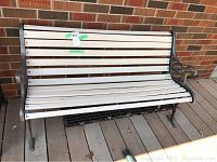 Front view of the white wooden slats on the outdoor bench with metal sides.
