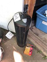 Full view of the black Stinger mosquito repellent unit with one Mosquito Control refill box on the ground in front.