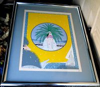 Front view showing framed Erte lithograph in blue mat and silver frame
