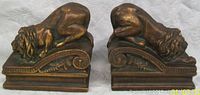 Front view of both bookends side by side showing reclining lions and scroll base design.