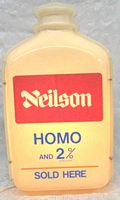 Front view of illuminated milk bottle shaped sign showing Neilson branding and text