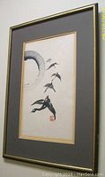 Framed watercolor painting showing five geese flying near a large circular brushstroke, mounted on cream paper with grey mat and gold frame.
