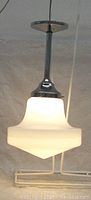 Full view of the lamp showing the hanging fixture, milk glass shade, and ceiling cap.