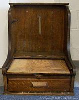 Front view of the oak wood cash register holder showing solid panel front and drawer beneath