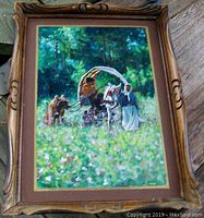 Framed oil painting showing travelers caravan with horse and figures in forest meadow
