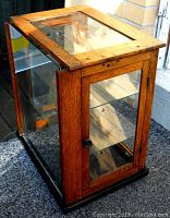 Side and front angle showing oak frame and glass shelves.