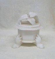 Full front photo of the marble box showing footed base and floral lid in white marble.