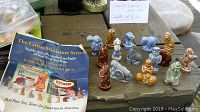 Complete set of 15 Wade Red Rose Tea Circus Series miniature porcelain figurines displayed on a wooden surface with promotional materials.
