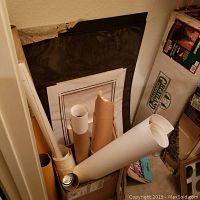 Rolled lithograph prints and art posters stored in tubes and cardboard box.