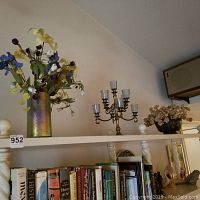 Overall view showing the metal flower vase with faux flowers on shelf with candleholder and metal bowl.