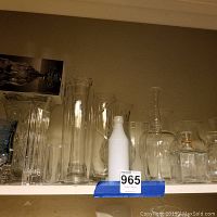 Shelf with multiple clear glass and crystal vases including a boxed Royal Limited crystal decanter