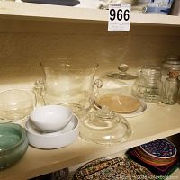 Shelved glass and ceramic bowls, candleholders, and serving trays.