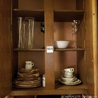 Cabinet showing stacked Porsgrund china sets and Wedgwood china.