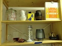 Overview of lot items showing candleholders, pitcher, vase, oil burners, canisters and Trick Pony bank on shelf
