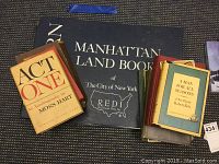 Sanborn Manhattan Land Book cover alongside a pile of assorted novels and history books.
