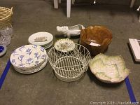 Photo showing 10 Royal Stafford Fine Earthenware dinner plates, 6 Limoges France salad plates, burlwood bowl, faience bowl, white wire basket and French shell form dish arranged on floor.
