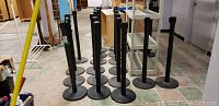 Multiple black stanchion posts arranged on tiled floor