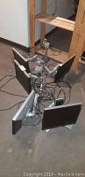 Five Dell 17 inch monitors arranged on the floor showing screens and mounts from the rear side