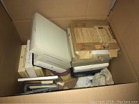 Several boxed porcelain plates and books packed inside a cardboard box for transport or storage.